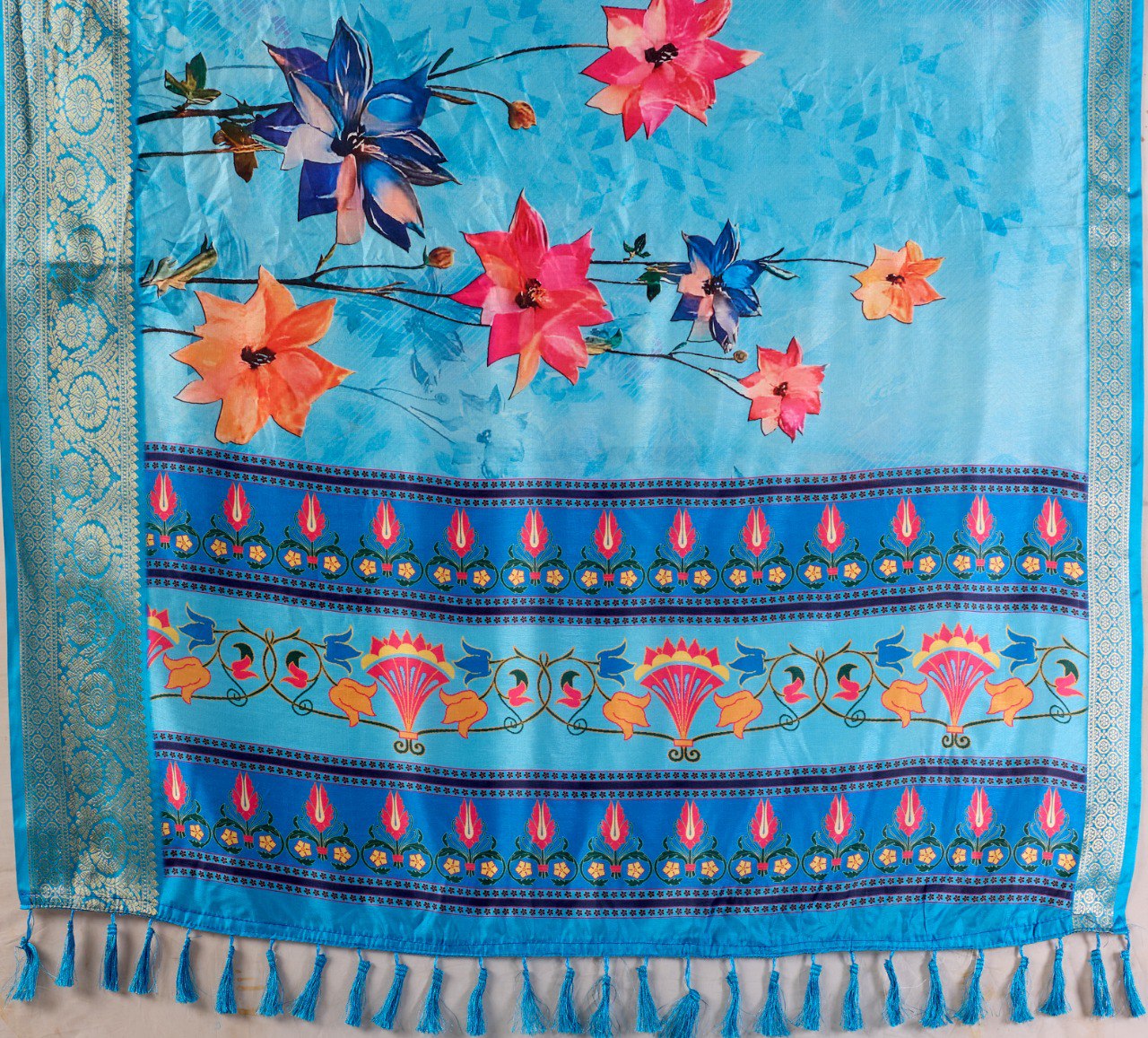 Soft Lichi Silk Saree in Serene Sky Blue Tone adorned with mesmerizing lotus-inspired digital prints and complemented by a luxurious golden zari woven border & pallu