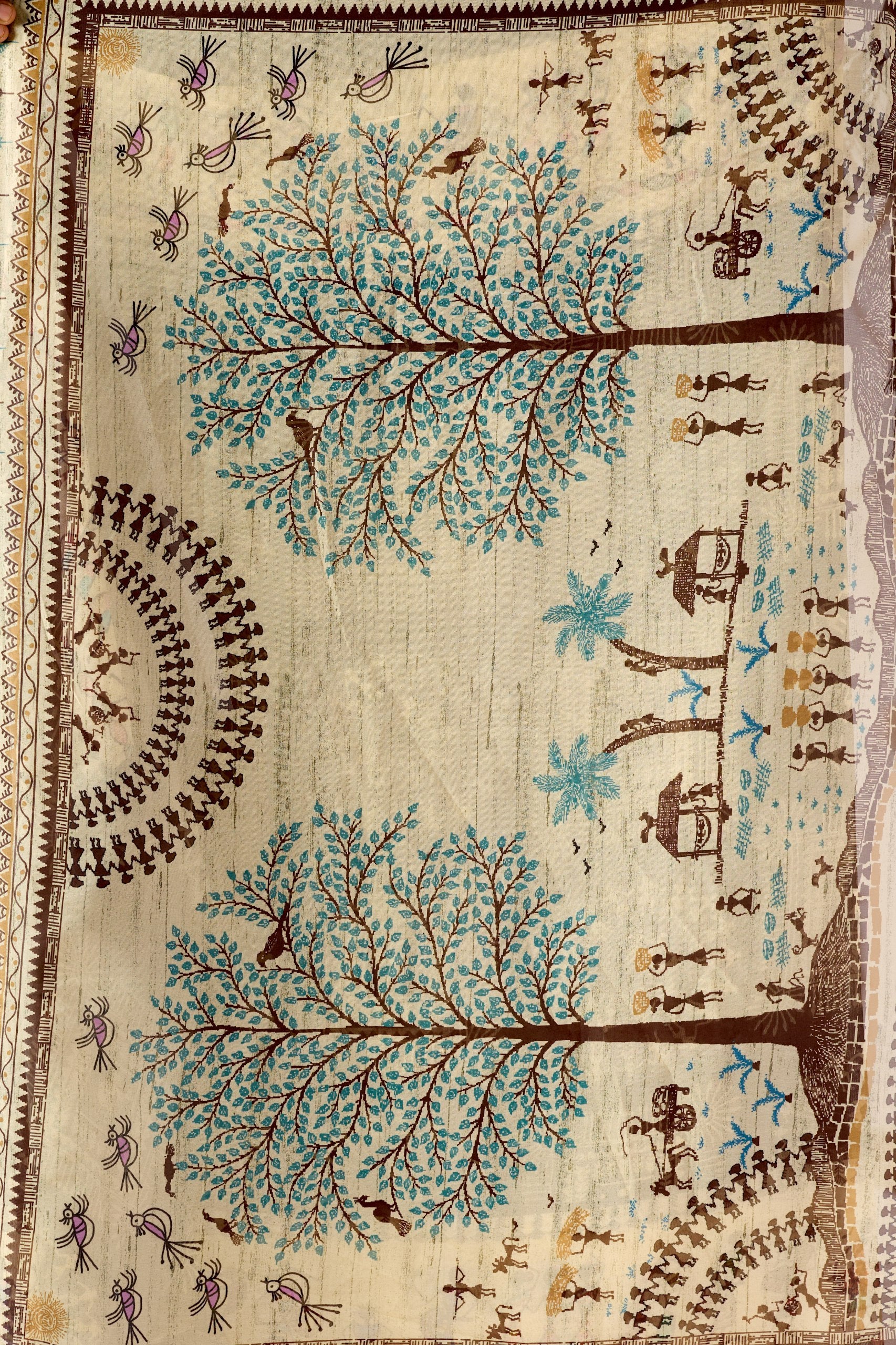 Soft Georgette Saree in Olive Green with Traditional Tribal Warli-Inspired Digital Prints and Rich Beige Panels Highlighted with Nature, Dance & Village Motifs + Intricate Tassel Detailing on the Pallu