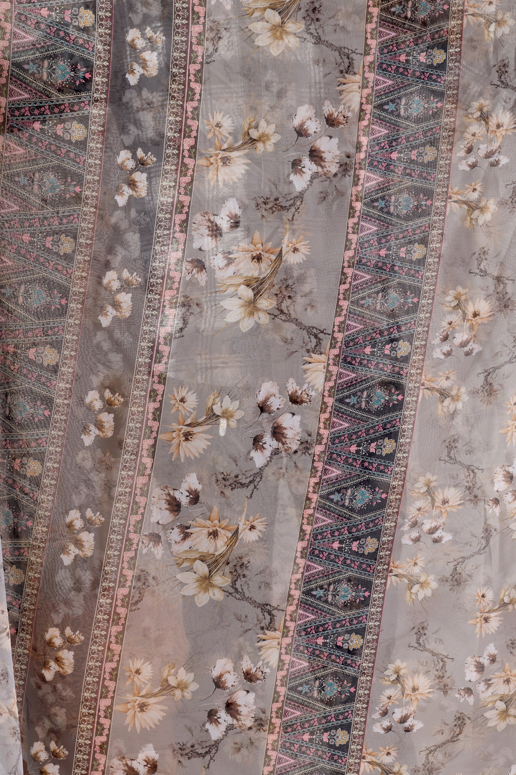 Soft Georgette Saree in Muted Grey Base Adorned with All-Over Floral Digital Print and Enhanced with Ornate Tribal-Style Patterned Pallu Featuring Pink, Black & Teal Accents + Elegant Black Tassel Detailing