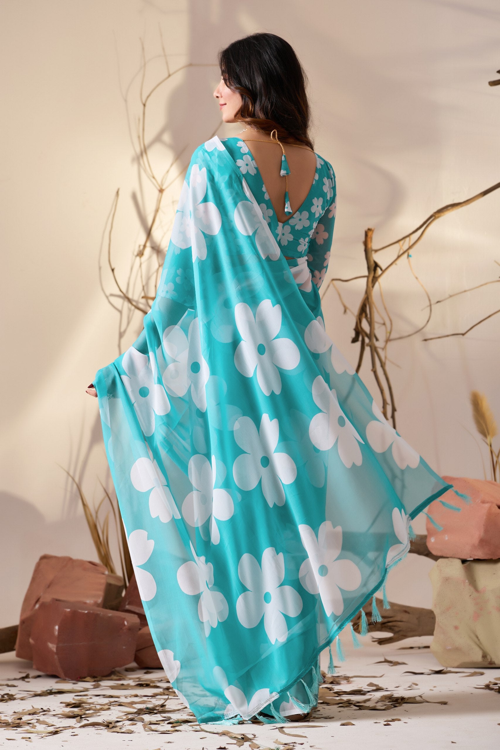 Soft Georgette Saree in Aqua Blue Shade Beautified with Bold White Oversized Floral Digital Print & Finished with Playful Tassel Detailing on Pallu