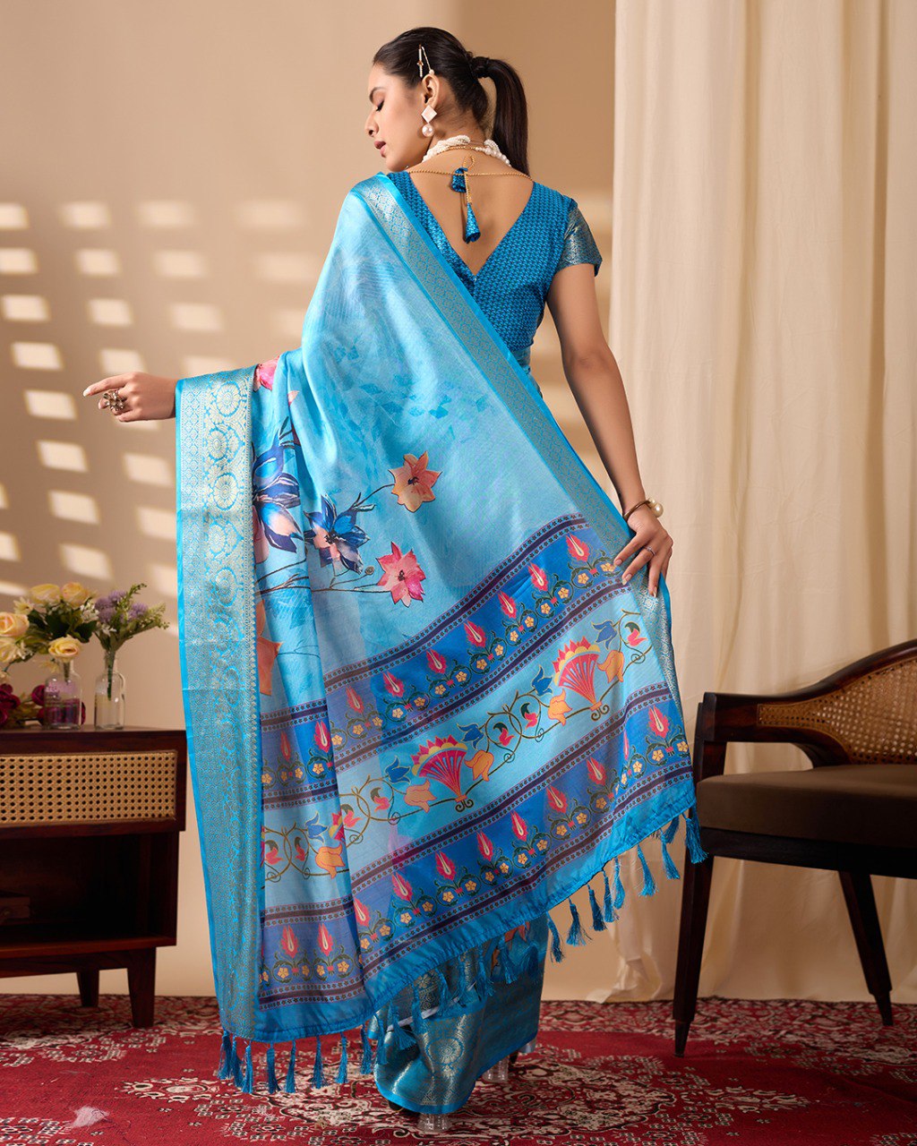 Soft Lichi Silk Saree in Serene Sky Blue Tone adorned with mesmerizing lotus-inspired digital prints and complemented by a luxurious golden zari woven border & pallu
