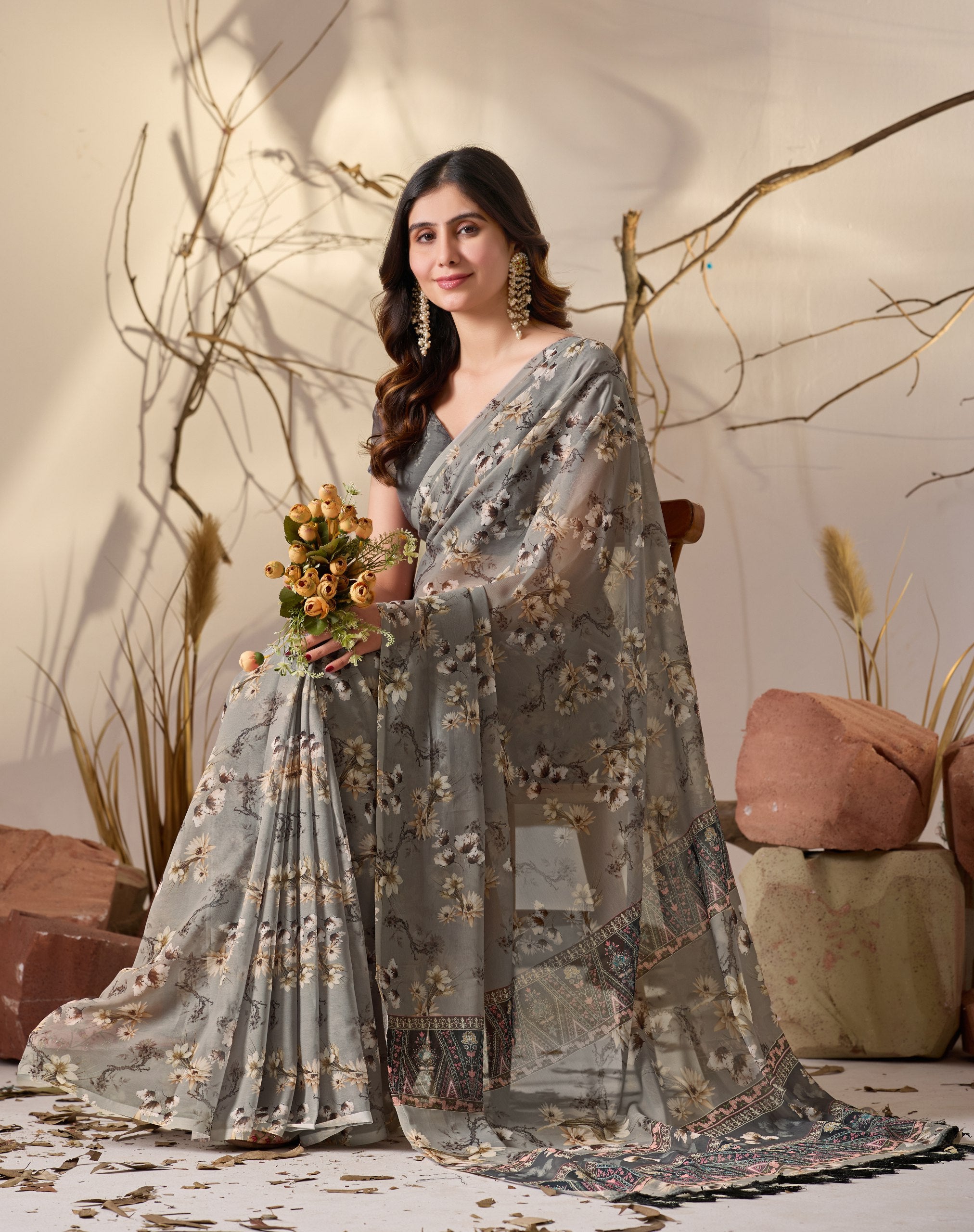 Soft Georgette Saree in Muted Grey Base Adorned with All-Over Floral Digital Print and Enhanced with Ornate Tribal-Style Patterned Pallu Featuring Pink, Black & Teal Accents + Elegant Black Tassel Detailing