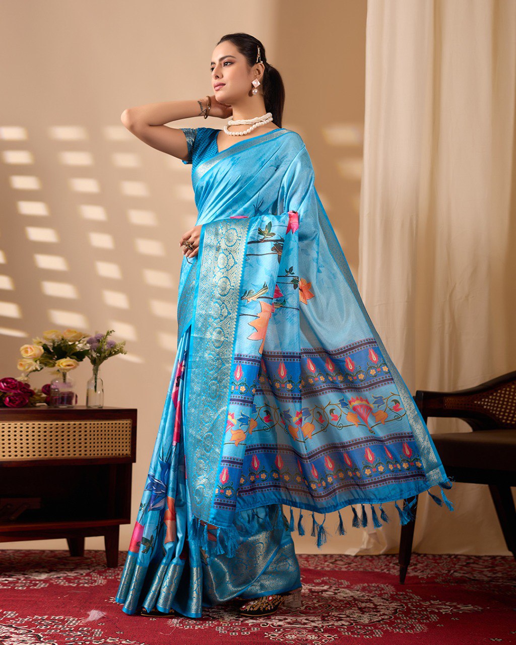 Soft Lichi Silk Saree in Serene Sky Blue Tone adorned with mesmerizing lotus-inspired digital prints and complemented by a luxurious golden zari woven border & pallu