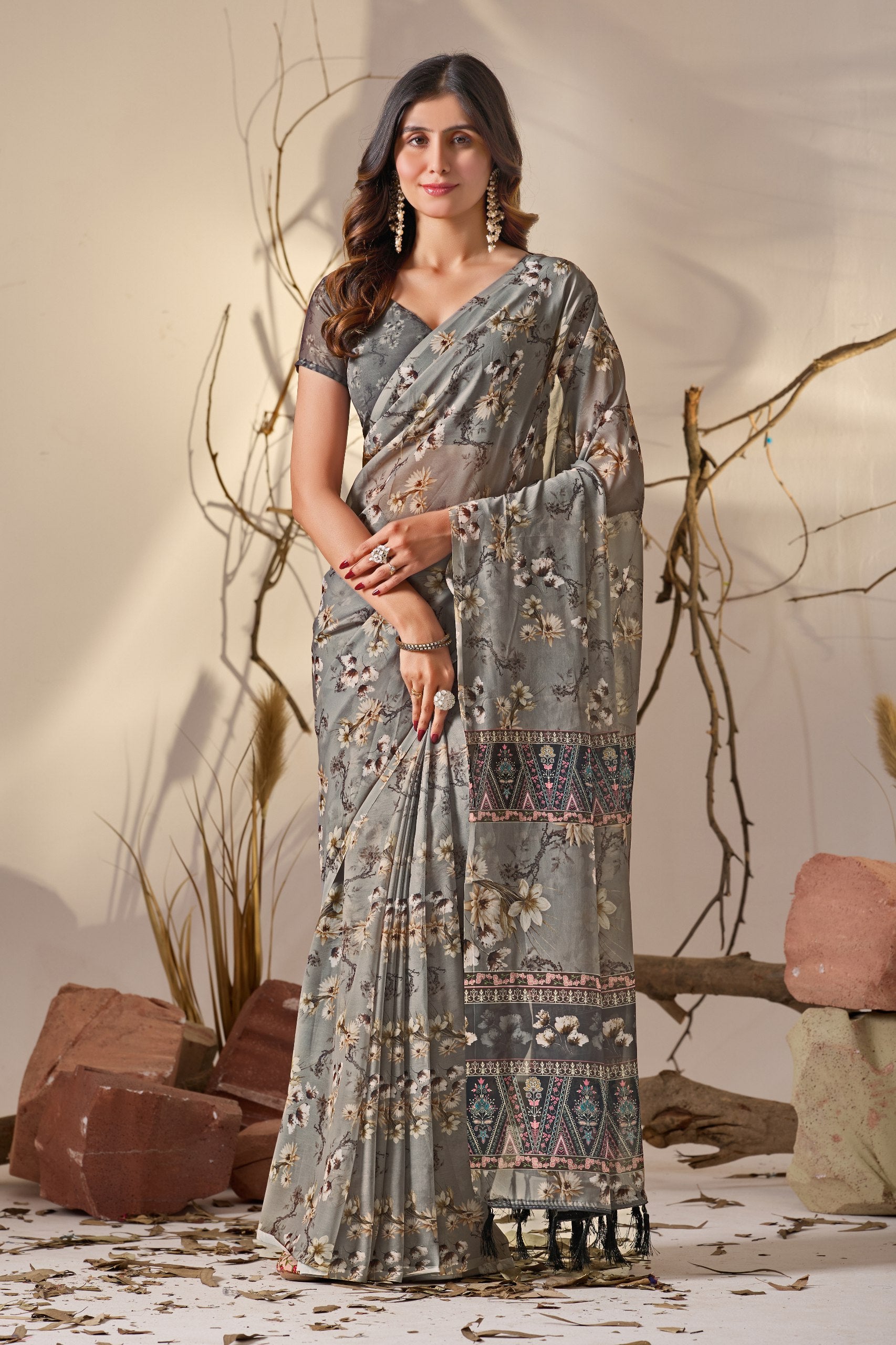 Soft Georgette Saree in Muted Grey Base Adorned with All-Over Floral Digital Print and Enhanced with Ornate Tribal-Style Patterned Pallu Featuring Pink, Black & Teal Accents + Elegant Black Tassel Detailing